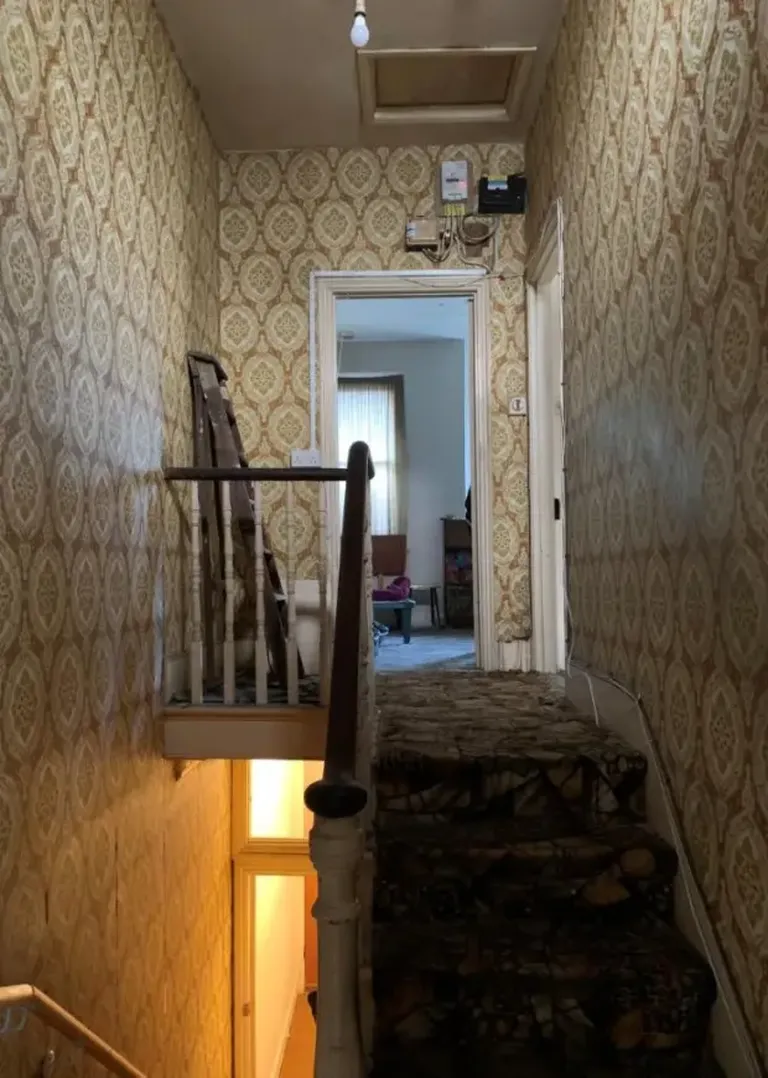 The stair area: stained carpets and deteriorated wallpaper