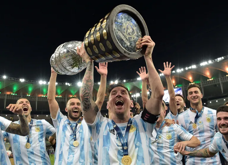 Lionel Messi holds the trophy as he celebrates with his teammates after winning the 2021 Copa America final against Brazil at the Maracana Stadium in Rio de Janeiro