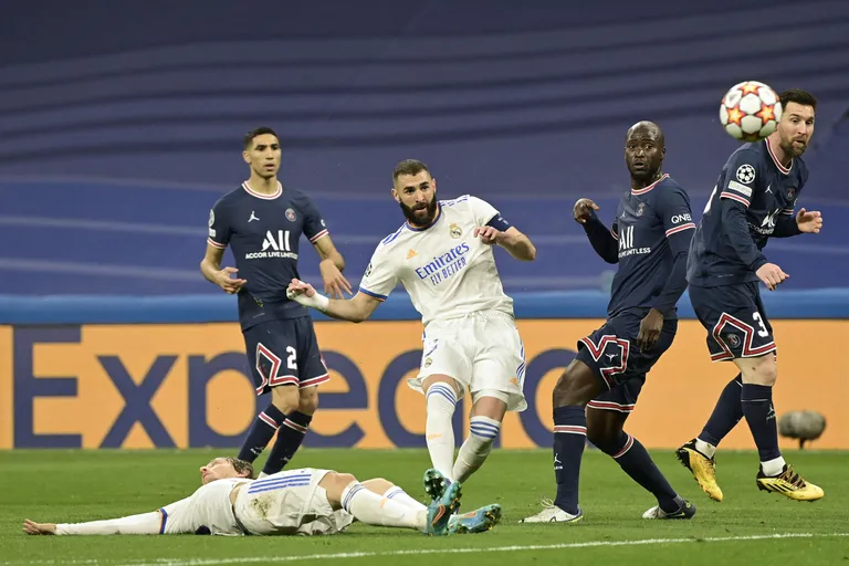 Real Madrid's French forward Karim Benzema (C) shoots the ball during the UEFA Champions League round of 16 second league football match between Real Madrid CF and Paris Saint-Germain at the Santiago Bernabeu stadium in Madrid on March 9, 2022. (Photo by JAVIER SORIANO / AFP)