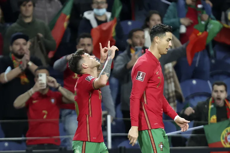 Portugal's Otavio Monteiro, left, celebrates with Cristiano Ronaldo after scoring the opening goal during the playoff match against Turkey